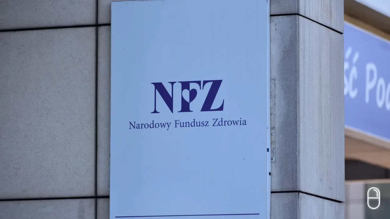 Niebieska tablica z logo NFZ i napisem Narodowy Fundusz Zdrowia zamocowana na kamiennej ścianie budynku.