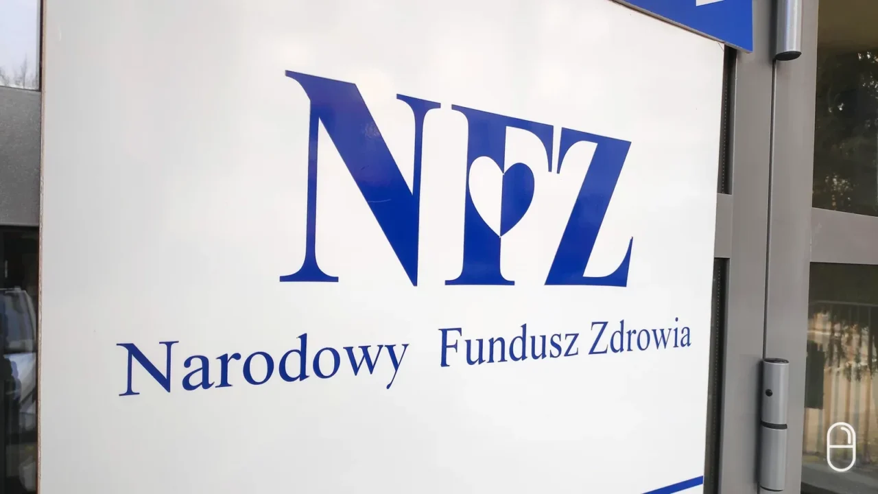 Tablica z logo Narodowego Funduszu Zdrowia przy wejściu do budynku funduszu.