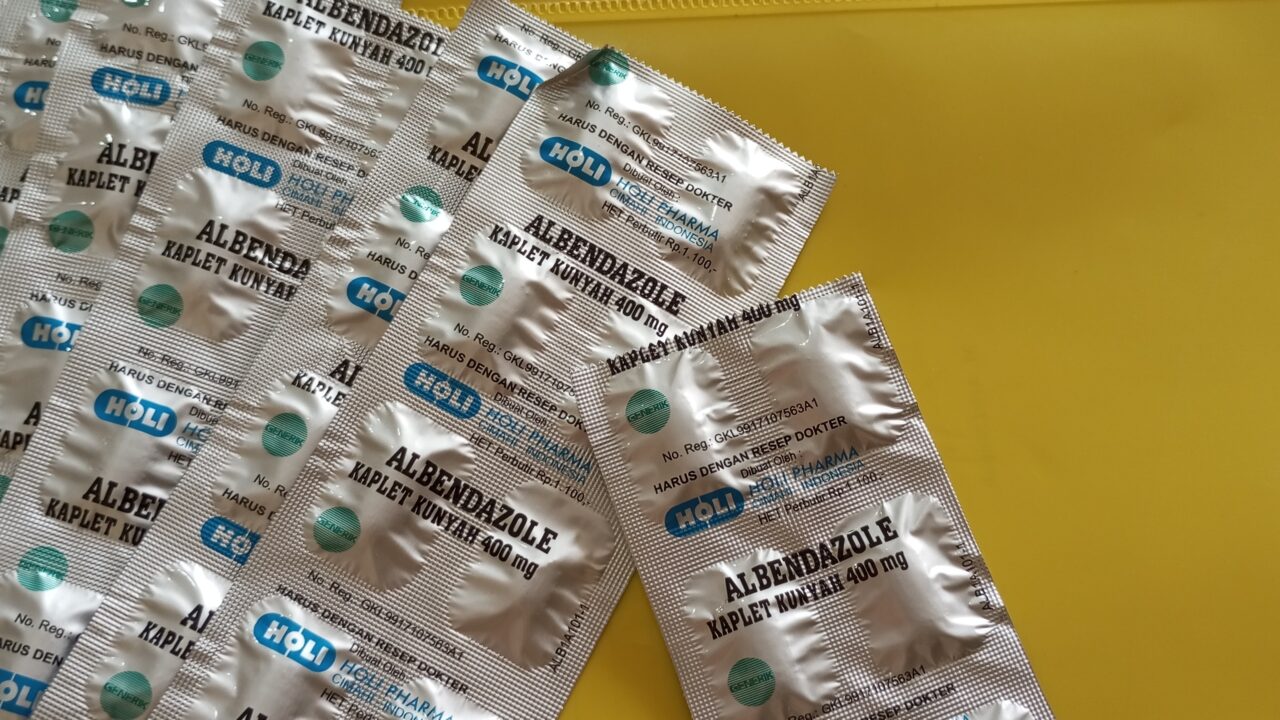Blistry tabletek albendazolu 400 mg rozłożone na żółtym blacie